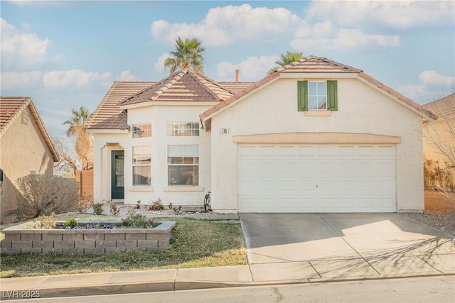 view of front facade featuring a tile roof, concrete driveway, and stucco siding