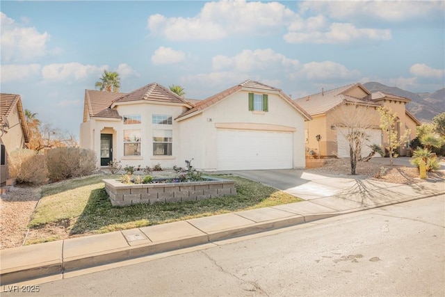 mediterranean / spanish house with driveway, an attached garage, a tiled roof, and stucco siding