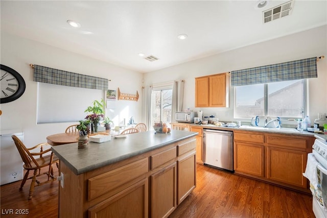 kitchen with white microwave, a sink, visible vents, stainless steel dishwasher, and range