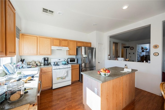 kitchen featuring under cabinet range hood, gas range gas stove, wood finished floors, and stainless steel fridge with ice dispenser