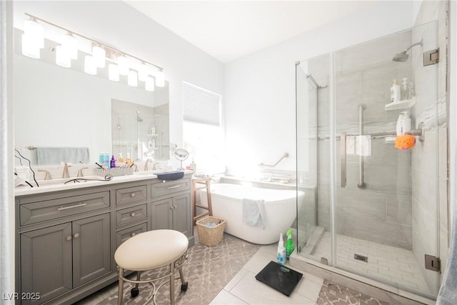 full bath with a sink, a freestanding bath, a shower stall, tile patterned floors, and double vanity