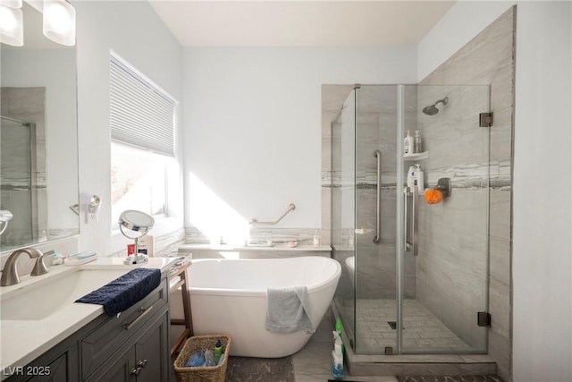 bathroom with a stall shower, a freestanding bath, and vanity