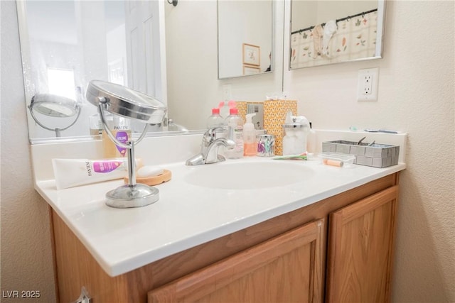 bathroom featuring a textured wall and vanity