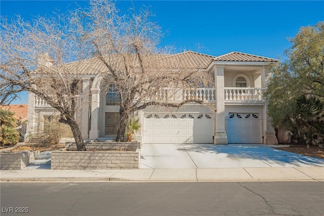 mediterranean / spanish-style house featuring driveway, a tile roof, a balcony, and stucco siding