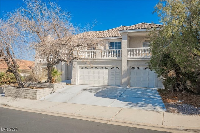 mediterranean / spanish-style house featuring a tile roof, stucco siding, concrete driveway, an attached garage, and a balcony