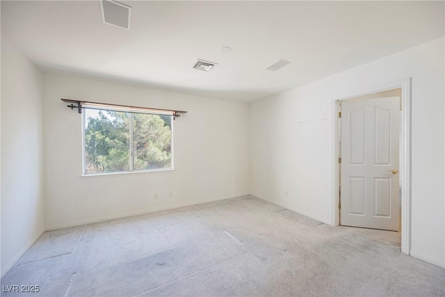 spare room featuring baseboards, visible vents, and light colored carpet