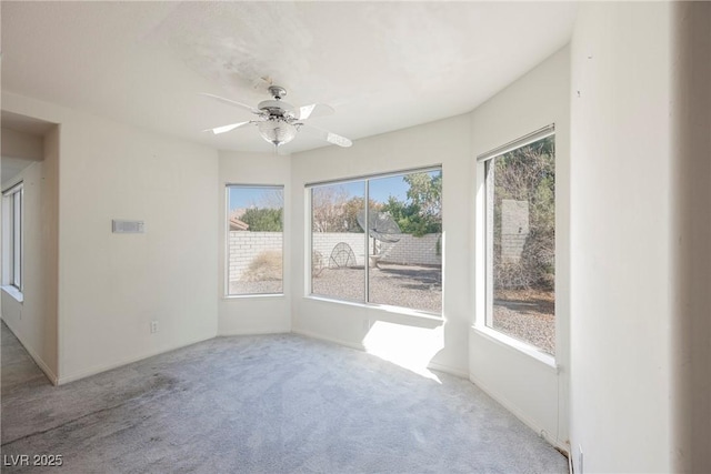 unfurnished sunroom with a ceiling fan