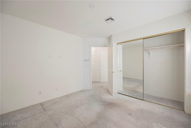 unfurnished bedroom featuring carpet floors, a closet, and visible vents