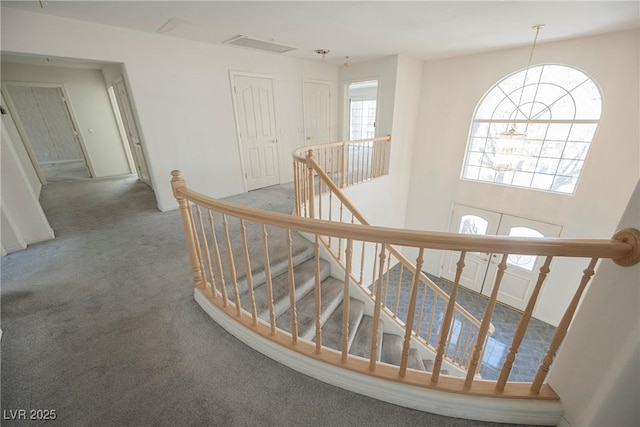 hall featuring carpet flooring and an upstairs landing