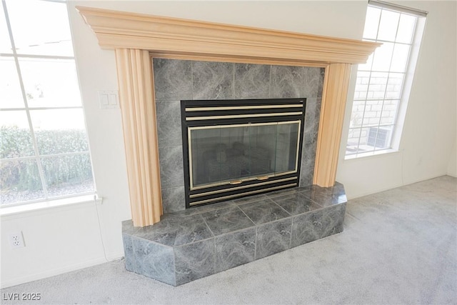 room details with a tiled fireplace and carpet flooring