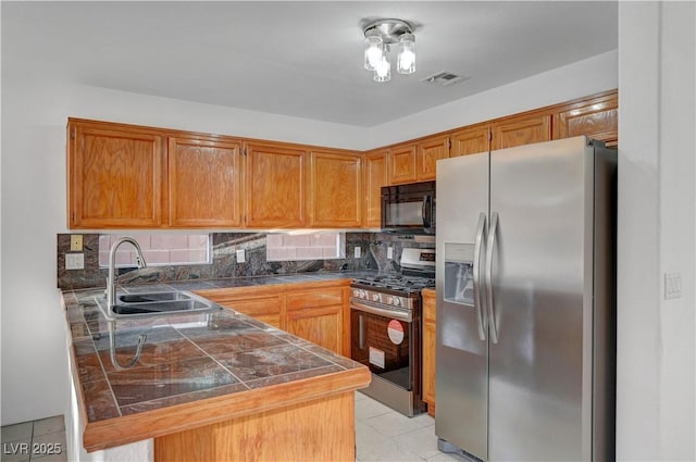 kitchen featuring tasteful backsplash, visible vents, tile countertops, stainless steel appliances, and a sink