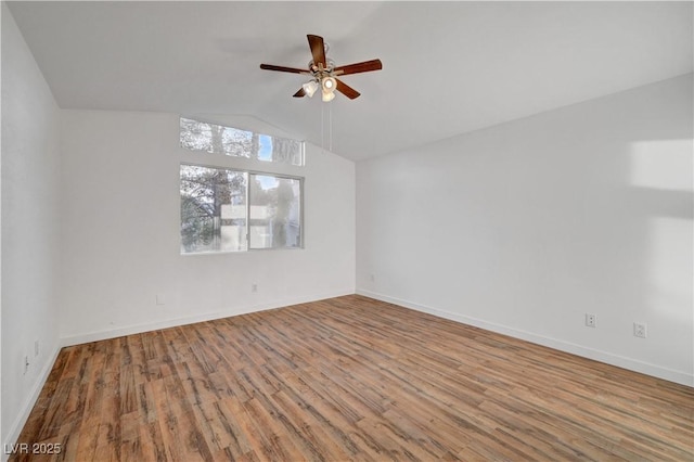 spare room with lofted ceiling, a ceiling fan, baseboards, and wood finished floors