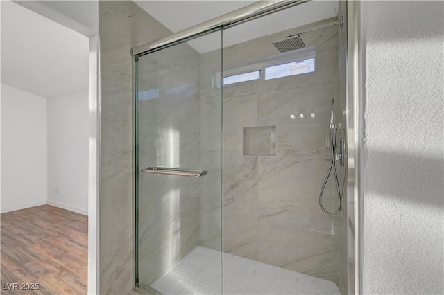 full bathroom featuring a marble finish shower and wood finished floors