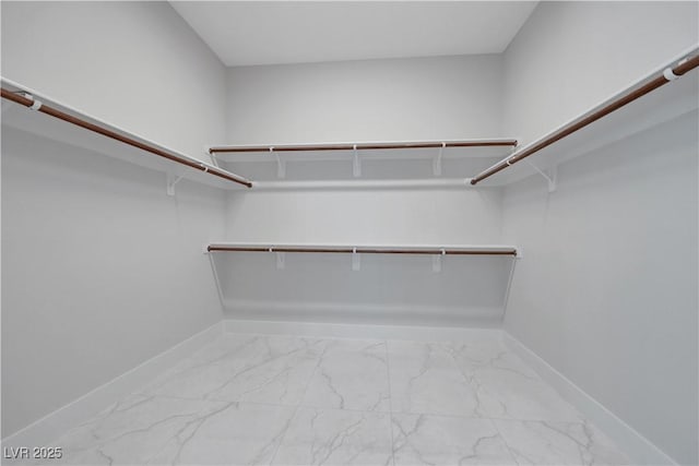 walk in closet featuring marble finish floor