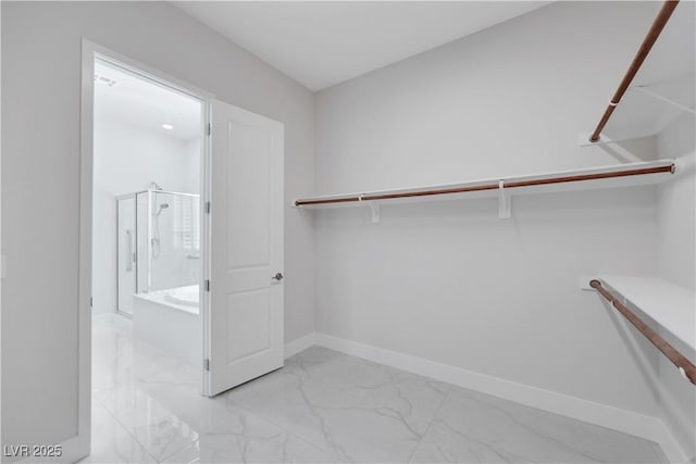 walk in closet with marble finish floor