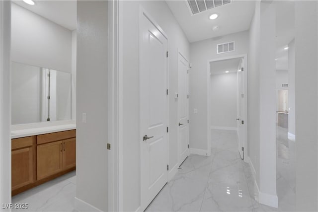 hall with marble finish floor, visible vents, and baseboards