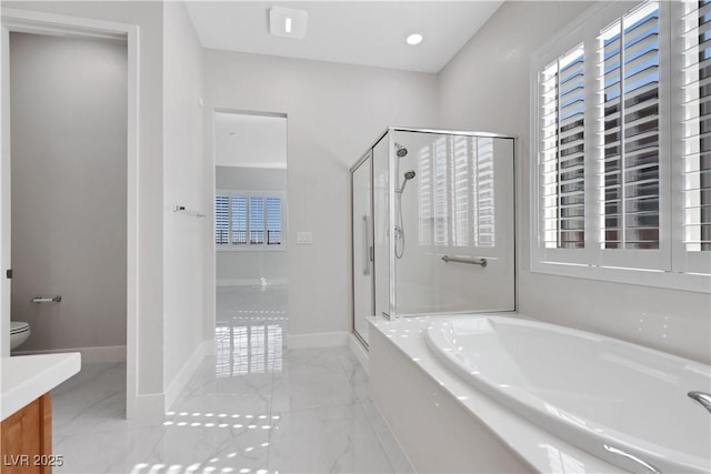 bathroom with a stall shower, marble finish floor, baseboards, and a bath