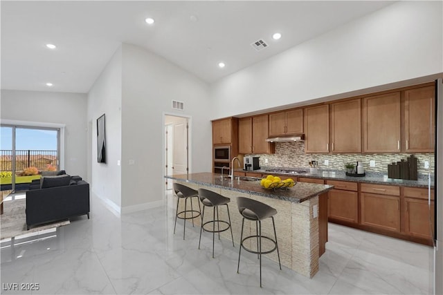 kitchen featuring marble finish floor, visible vents, and under cabinet range hood