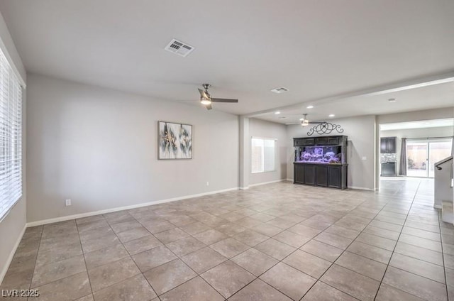 unfurnished living room with visible vents, tile patterned flooring, a ceiling fan, and baseboards