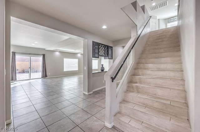 stairway featuring tile patterned flooring, visible vents, baseboards, and recessed lighting