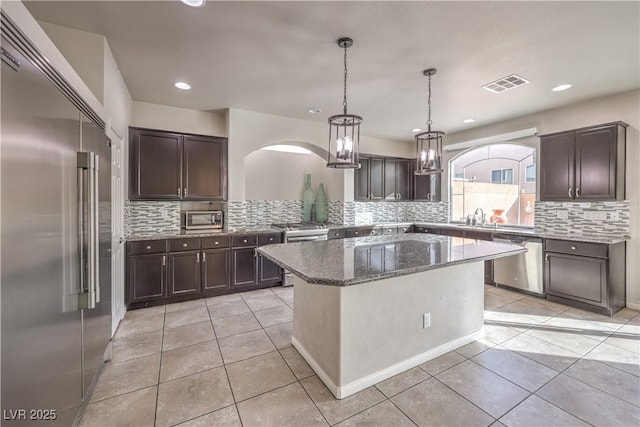 kitchen with dark brown cabinetry, appliances with stainless steel finishes, and light tile patterned flooring