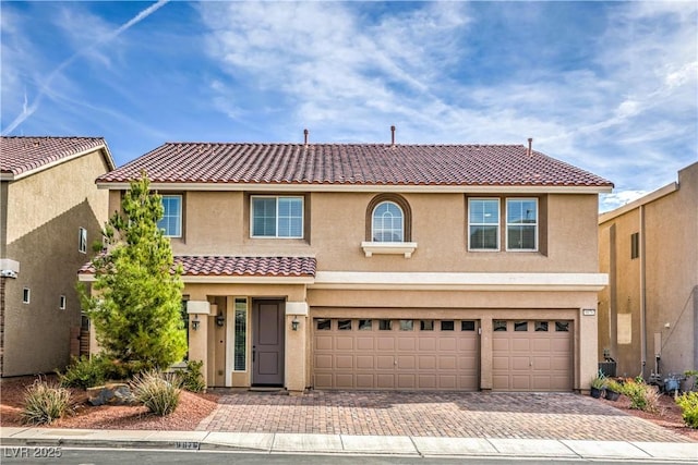 view of front of property with a tiled roof, decorative driveway, and stucco siding