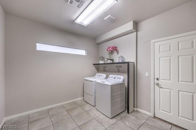 laundry area featuring laundry area, visible vents, baseboards, washing machine and clothes dryer, and light tile patterned flooring