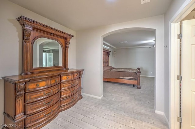 hall with arched walkways, baseboards, visible vents, and wood tiled floor