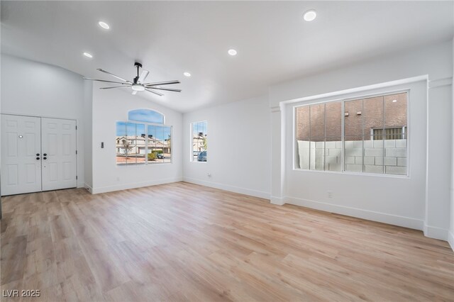 unfurnished living room with a ceiling fan, baseboards, recessed lighting, vaulted ceiling, and light wood-style floors