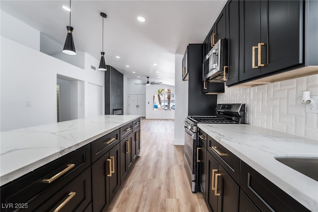 kitchen with stainless steel appliances, dark cabinetry, and decorative backsplash