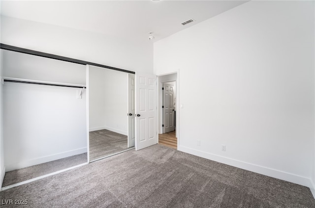 unfurnished bedroom featuring a closet, baseboards, and carpet