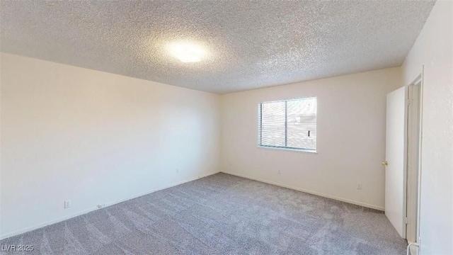 carpeted empty room with a textured ceiling