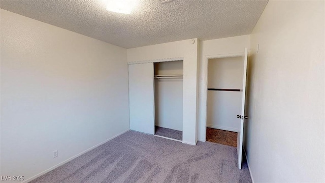 unfurnished bedroom with carpet, a closet, and a textured ceiling