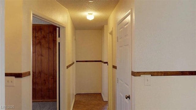 hallway with a textured ceiling