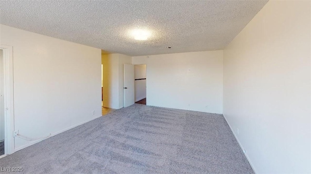 carpeted empty room featuring a textured ceiling