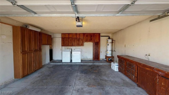 garage with a garage door opener, independent washer and dryer, and water heater