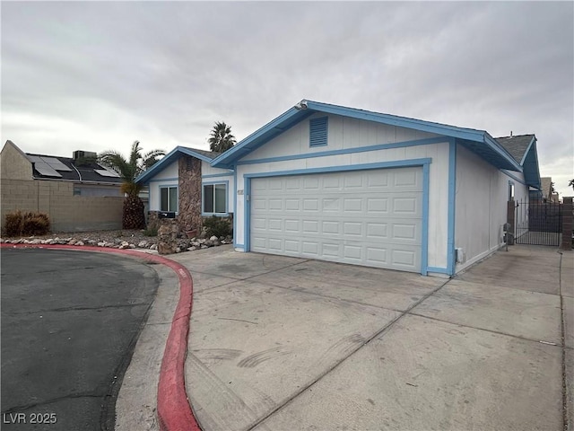 view of front of property with a garage, concrete driveway, and fence