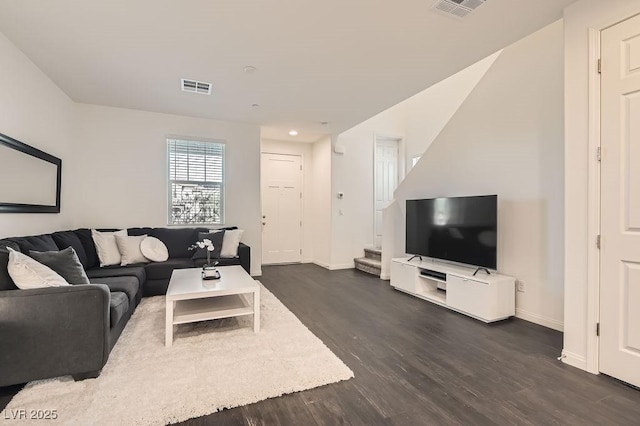 living area with baseboards, stairs, visible vents, and dark wood-style flooring