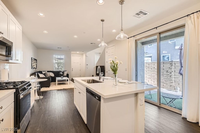 kitchen featuring a sink, visible vents, open floor plan, appliances with stainless steel finishes, and dark wood-style floors