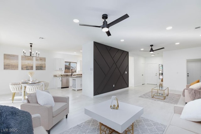 living area featuring ceiling fan with notable chandelier, visible vents, and recessed lighting