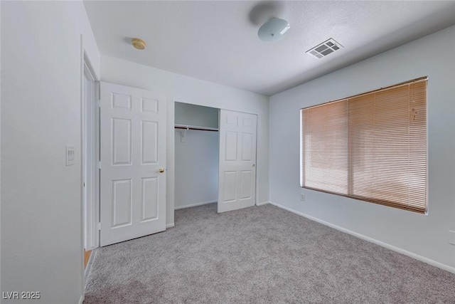 unfurnished bedroom with carpet, a closet, visible vents, and baseboards