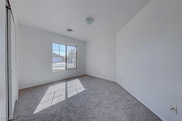 carpeted empty room with visible vents and baseboards