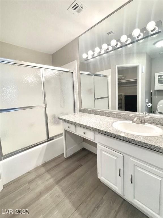 6250 W Flamingo Rd Unit 103, Las Vegas, NV 89103 - full bath with vanity, enclosed tub / shower combo, wood finished floors, and a spacious closet