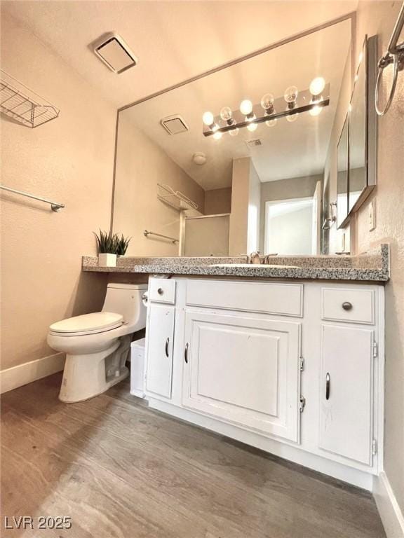 6250 W Flamingo Rd Unit 103, Las Vegas, NV 89103 - full bathroom featuring toilet, wood finished floors, vanity, and baseboards