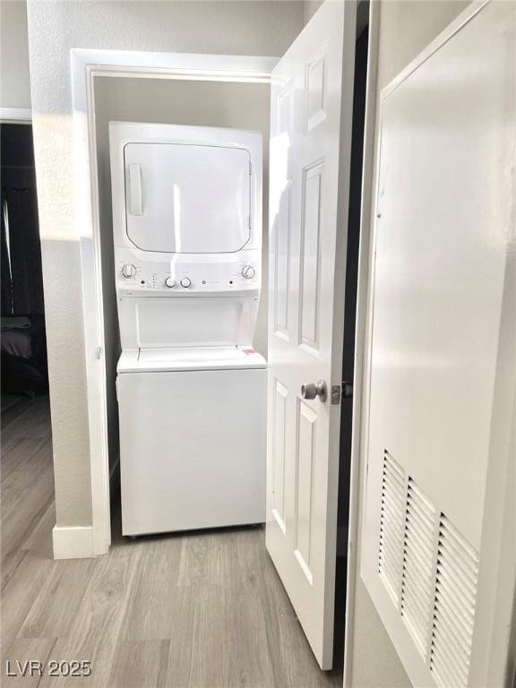 6250 W Flamingo Rd Unit 103, Las Vegas, NV 89103 - washroom featuring stacked washing machine and dryer and light wood-type flooring
