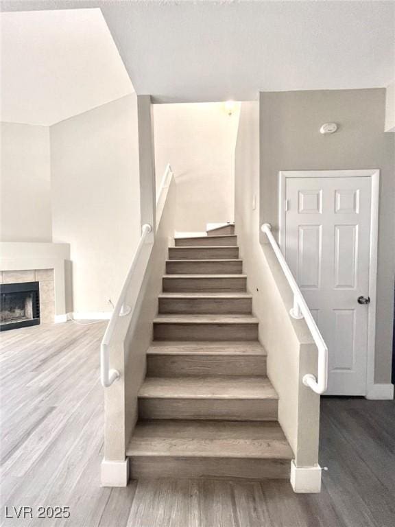 6250 W Flamingo Rd Unit 103, Las Vegas, NV 89103 - staircase with wood finished floors, baseboards, and a tile fireplace