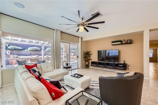 living room with ceiling fan, tile patterned flooring, visible vents, and baseboards