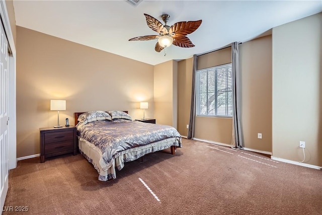 carpeted bedroom with ceiling fan, baseboards, and a closet