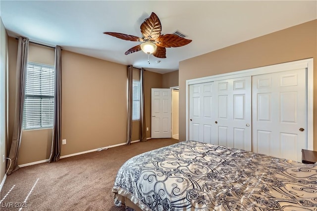 bedroom featuring baseboards, visible vents, ceiling fan, carpet, and a closet