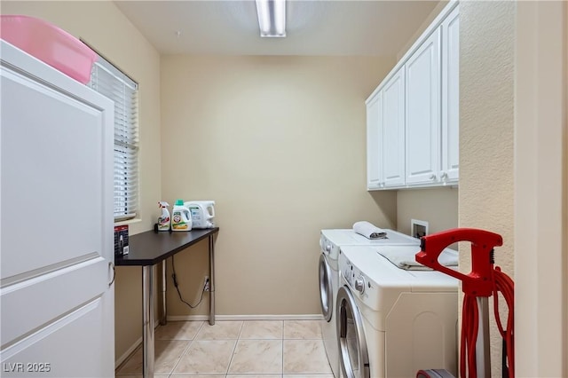 washroom featuring cabinet space, light tile patterned floors, baseboards, and independent washer and dryer